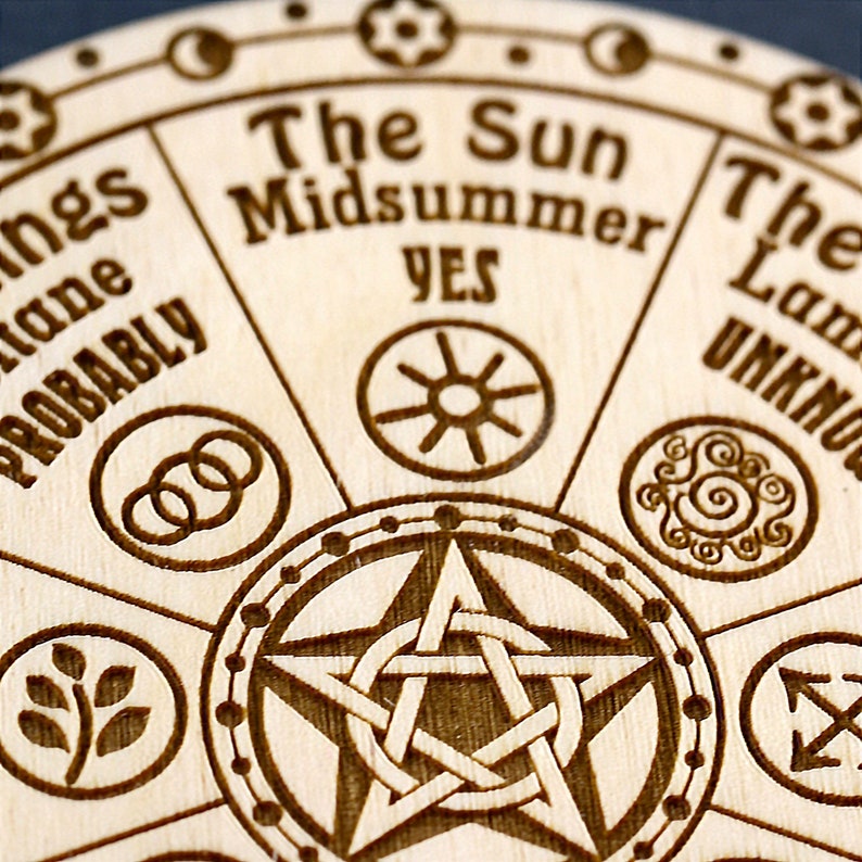 K&ouml;nnte beinhalten: Ein Ouija-Brett aus Holz mit einem Pentagramm in der Mitte und verschiedenen Symbolen am Rand. Das Brett tr&auml;gt die Aufschriften "The Sun Midsummer YES" und "The Law UNKNOW".