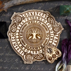 K&ouml;nnte beinhalten: Holz-Ouija-Brett mit einem Lebensbaum-Design, Zahlen, Buchstaben und den W&ouml;rtern "Hello" und "Goodbye". Ein Holz-Planchette mit einem nach unten zeigenden Pfeil ist ebenfalls enthalten.