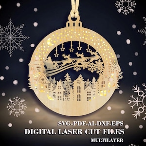 May include: A round, wooden Christmas ornament with a layered design. The ornament features a cutout scene of a village with Santa and reindeer, stars, and a crescent moon. The text "DIGITAL LASER CUT FILES" is at the bottom.