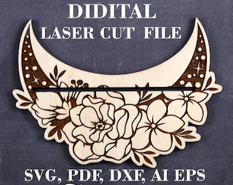 May include: A laser cut file for a tarot card stand. The stand is shaped like a crescent moon with floral details. The file is available in SVG, PDF, DXF, AI, and EPS formats.