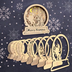 May include: A set of eight wooden Christmas ornaments featuring a Krampus figure, a house, and a tree. The ornaments are laser cut and have a delicate, intricate design. The top ornament has the text "Merry Krampus".