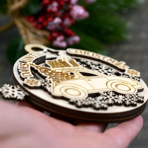 Puede incluir: Adorno de madera para la cuenta atr&aacute;s de Navidad con un coche vintage que lleva un &aacute;rbol de Navidad y regalos. El adorno est&aacute; decorado con copos de nieve y el texto "Days Until Christmas".