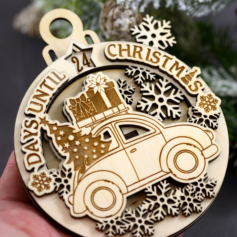 Puede incluir: Adorno de madera para la cuenta atr&aacute;s de Navidad con un coche que lleva un &aacute;rbol de Navidad y regalos. El adorno tiene un mecanismo deslizante para contar los d&iacute;as hasta Navidad. El adorno est&aacute; decorado con copos de nieve y el texto "24 d&iacute;as hasta Navidad".
