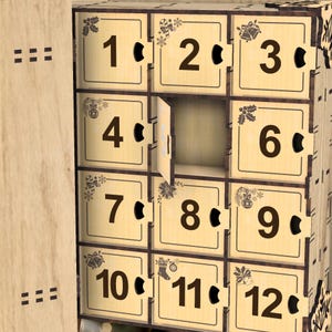 Peut inclure: Calendrier de l'Avent en bois avec douze compartiments num&eacute;rot&eacute;s, chacun avec une petite poign&eacute;e circulaire. Les chiffres sont en gras et chaque compartiment est d&eacute;cor&eacute; d'illustrations sur le th&egrave;me de No&euml;l. Une porte est ouverte.