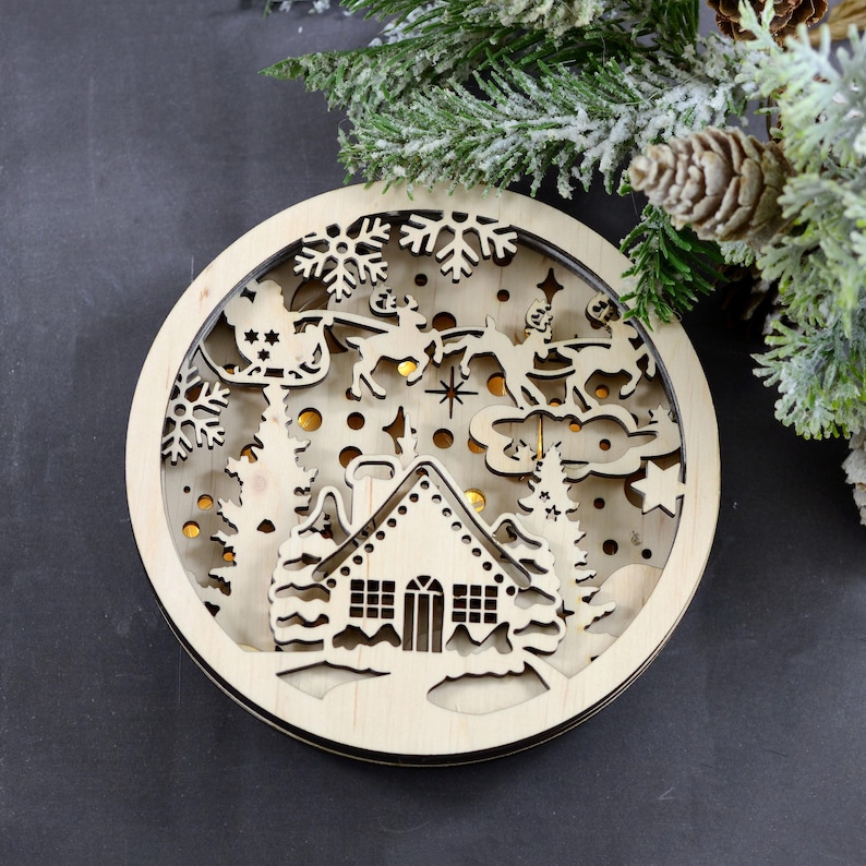 Pu&ograve; includere: Un ornamento natalizio in legno con un design a taglio di Santa Claus che vola su una slitta trainata da renne sopra un villaggio innevato. L'ornamento &egrave; illuminato da luci LED bianco caldo.