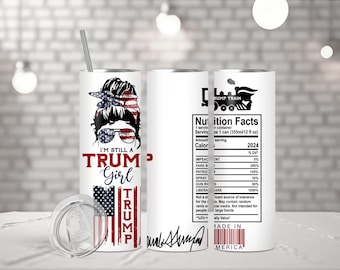 Puede incluir: Un vaso de acero inoxidable blanco con un diseño de bandera estadounidense roja, blanca y azul. El vaso presenta el rostro de una mujer con un moño y gafas de sol. El texto "I'm Still A Trump Girl" está impreso en el vaso. El otro lado del vaso presenta un tren con el texto "Trump Train" y una etiqueta de información nutricional con el texto "2024".