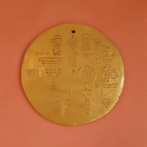 Gilded clay wall plaque with symbol