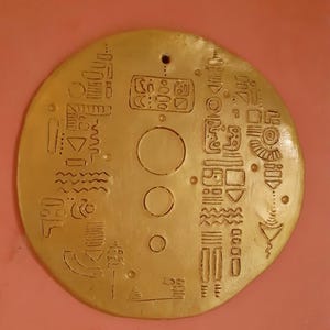 Gilded clay wall plaque with symbol