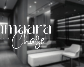 Puede incluir: Logotipo en blanco y negro para un estudio de diseño llamado "Kamaara Chase Design Studio". El logotipo está en una puerta de vidrio con un fondo borroso de un interior moderno.