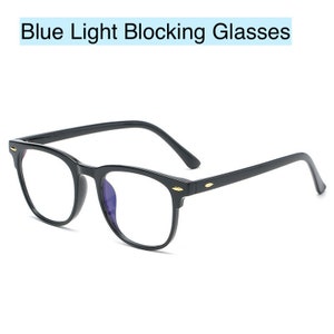 May include: Black square-shaped blue light blocking glasses with gold accents on the arms.