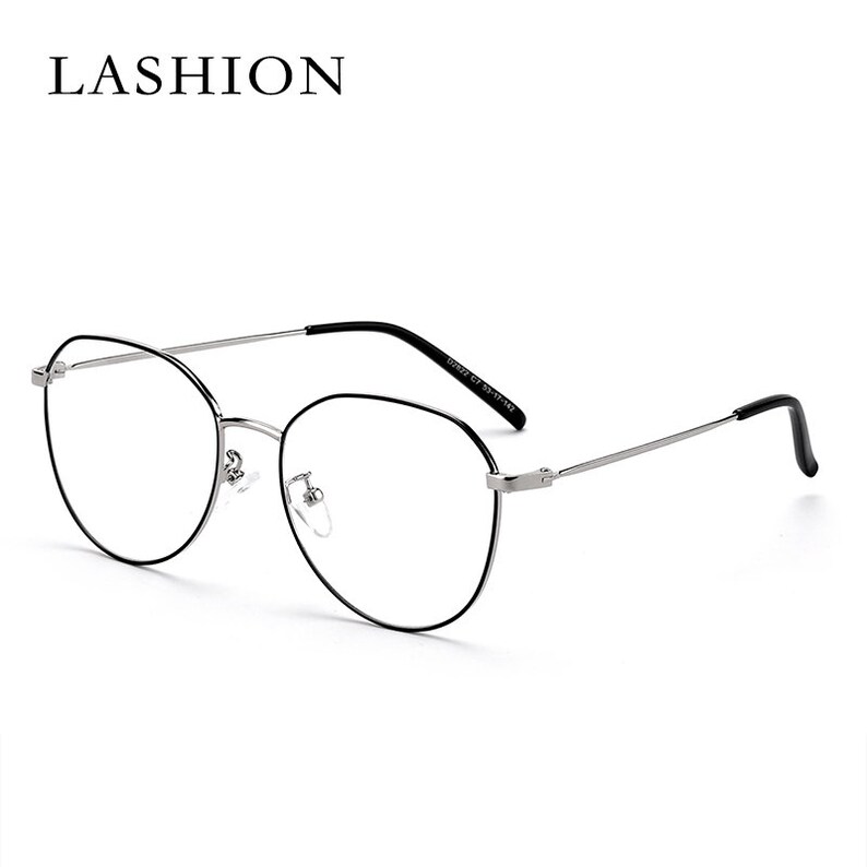 Puede incluir: Gafas con montura negra y aro plateado. Las gafas tienen una forma redonda y ovalada.