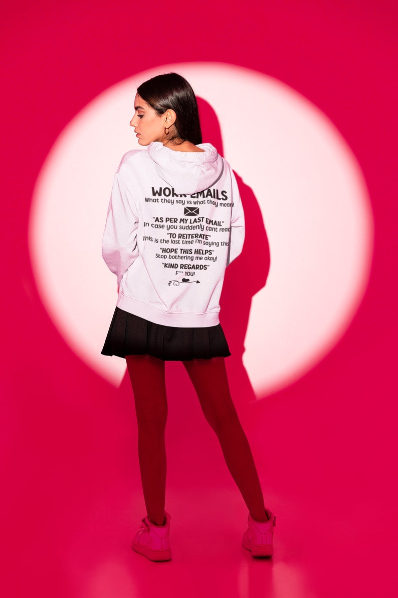 May include: A white hoodie with a black graphic print that says "Work Emails" and includes a message about "As per my last email" and "To reiterate". The model is wearing a black skirt and red tights.