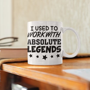 K&ouml;nnte beinhalten: Wei&szlig;e Keramik-Kaffeetasse mit schwarzem Text, der "Ich habe mit absoluten Legenden gearbeitet" lautet, und vier schwarzen Sternen.