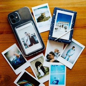 May include: A clear plastic photo album with a variety of photos inside. The photos include a couple, a cat, a building, and a person in a pool. The album is on a wooden surface.