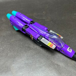 Peut inclure: Jet jouet violet et turquoise avec le mot "RAMJET" visible. Le jouet a un nez noir et un cockpit transparent. Un jouet de collection vintage.