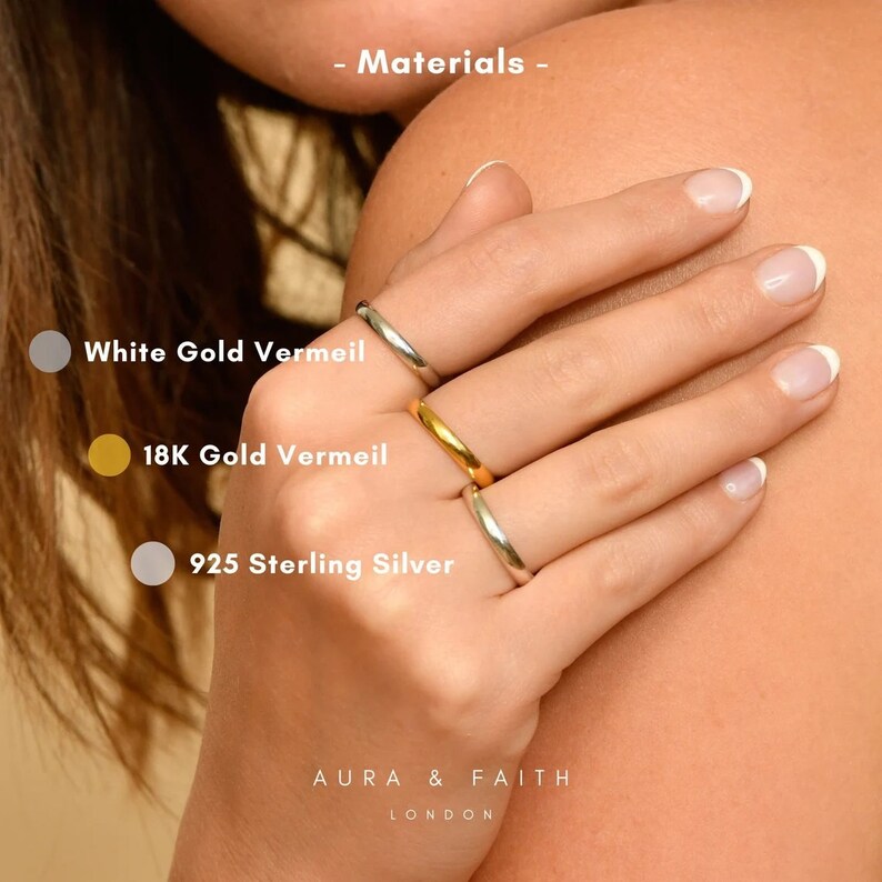Puede incluir: Tres anillos simples de oro en una mano. Los anillos est&aacute;n etiquetados como "White Gold Vermeil", "18K Gold Vermeil" y "925 Sterling Silver".