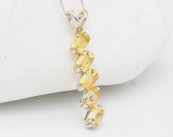 May include: A silver pendant necklace with a cascading design of six yellow gemstones. The gemstones are rectangular and faceted, creating a sparkling effect.