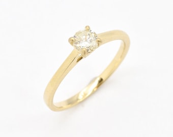 May include: A simple gold band ring with a single round diamond.