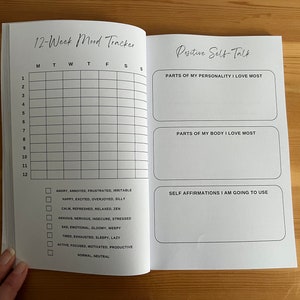 May include: A 12-week mood tracker journal with a grid for tracking moods daily. The journal includes a section for positive self-talk with prompts for listing parts of your personality and body you love most, and a section for writing self-affirmations.