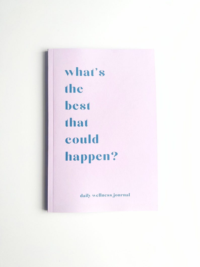 May include: A lavender-colored journal with the text "what's the best that could happen?" and the words "daily wellness journal" at the bottom.