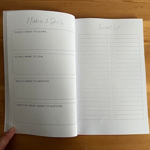 May include: A blank notebook with a black and white design. The left page has the title "Hobbies & Skills" and sections for "Things I Want to Learn", "Clubs I Want to Join", "Skills I Want to Improve", and "Creative Ideas I Want to Nurture". The right page has the title "Bucket List" and two columns of blank lines.