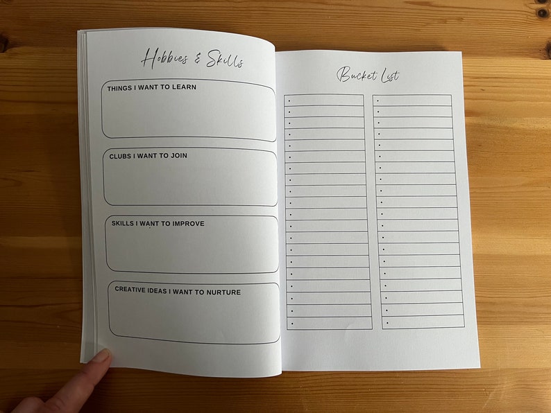 May include: A blank notebook with a black and white design. The left page has the title "Hobbies & Skills" and sections for "Things I Want to Learn", "Clubs I Want to Join", "Skills I Want to Improve", and "Creative Ideas I Want to Nurture". The right page has the title "Bucket List" and two columns of blank lines.