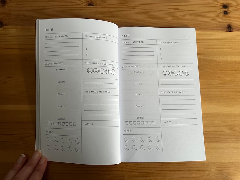 May include: A two-page spread from a daily planner or journal with sections for "Date", "Today, I intend to", "My Affirmations", "Balanced Diet", "Thoughts & Feelings", "This Made Me Smile", "Water", "Sleep", and "Notes".