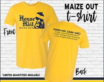 May include: Yellow t-shirt with a blue graphic of a person wearing sunglasses and a hat. The text "House of Hail" and "MAIZE OUT" is printed on the front of the shirt. The back of the shirt has the text "MAIZE OUT t-shirt" and a definition of the term "maize out".