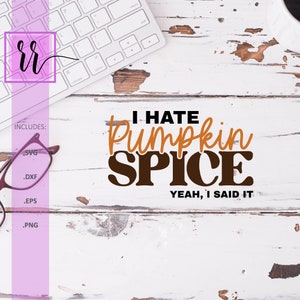 May include: White wooden surface with the text "I HATE Pumpkin SPICE YEAH, I SAID IT" in brown and orange. A keyboard, glasses, and a coffee cup are also visible.