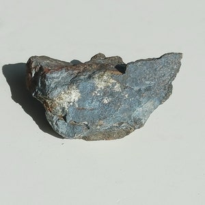 May include: A rough, gray and brown rock with a blue-gray coating. The rock has a unique, irregular shape and a textured surface.
