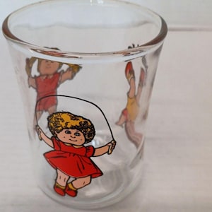 Vaso de jugo vintage de Cabbage Patch Kids de 1984, estilo retro, para exhibición en la cocina.