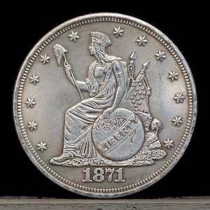 May include: A silver coin with a seated figure of Liberty holding a staff and a shield with the word "LIBERTY" inscribed. The coin has a date of "1871" and is surrounded by 13 stars.