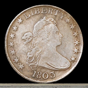 May include: A silver US dollar coin with a portrait of Liberty and the year 1803. The coin has 13 stars around the edge.