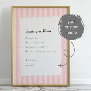 Peut inclure: Une impression encadrée avec un cadre doré, avec un fond à rayures roses et blanches. L'impression comprend le texte "Thank you, Mom" et un message personnalisé. Le design général est un hommage sincère.