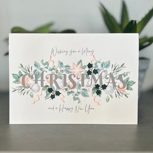 Carte de Noël moderne, carte de boules de Noël roses et argentées, carte de Noël décorée à la main avec houx 3D, pierres précieuses et perles, carte scène d'hiver
