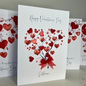 May include: A white card with a red heart-shaped tree with red hearts on the branches. The card says "Happy Valentine's Day" and "Catherine".