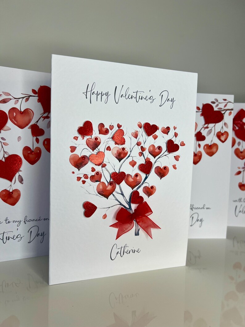 May include: A white card with a red heart-shaped tree with red hearts on the branches. The card says "Happy Valentine's Day" and "Catherine".