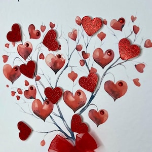 May include: A white card featuring a watercolour painting of a tree with red hearts. The tree has a red ribbon bow at its base. The hearts are painted in various shades of red and some have glitter.