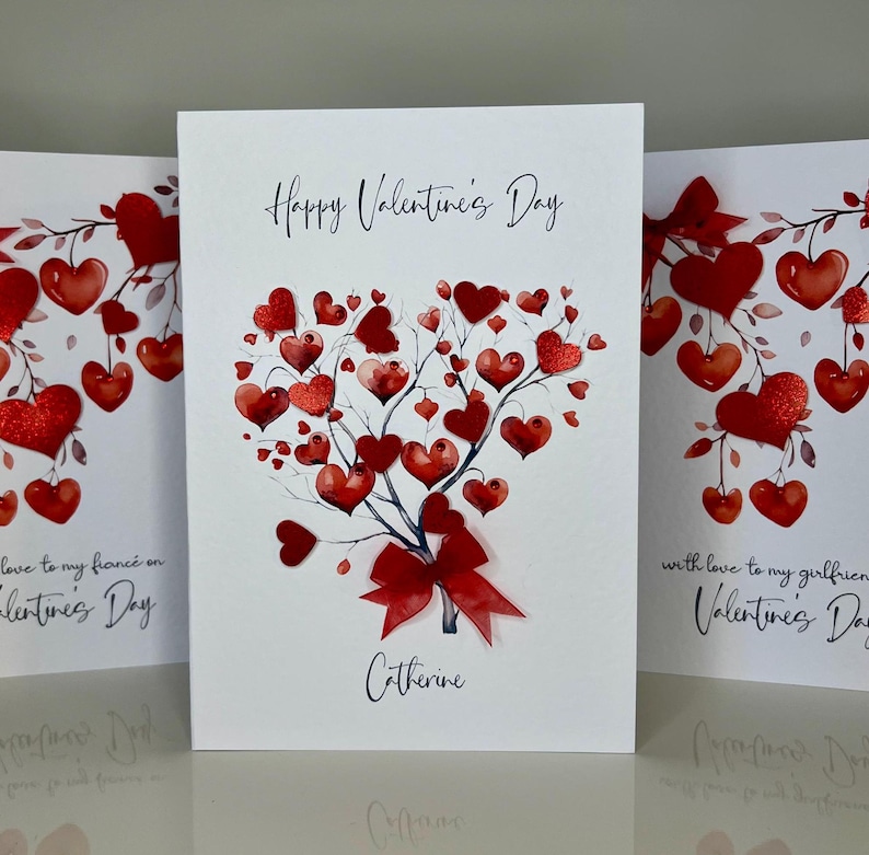 May include: A white card with a red watercolour heart tree design. The card says "Happy Valentine's Day" and "Catherine".