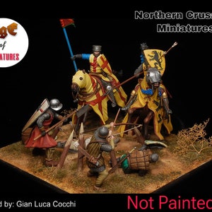 Op de afbeelding: Miniatuur diorama met een middeleeuwse gevechtsscène met ridders te paard en voetsoldaten. De figuren zijn gedetailleerd geschilderd, met gele en rode heraldische ontwerpen. De tekst "Northern Crusades Miniatures" is zichtbaar.