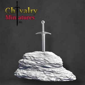 May include: A silver sword is stuck in a white rock. The rock is textured and has a rough surface. The sword has a silver hilt and a silver blade. The text "Chivalry Miniatures 3D" is visible in the top left corner of the image.