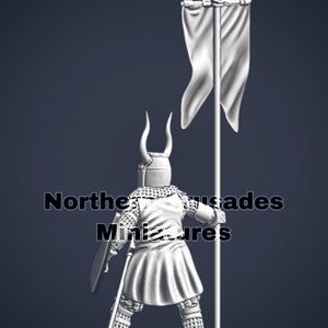 May include: A white metal miniature of a crusader knight holding a sword and shield, standing next to a white flag with a cross on top. The miniature is wearing chainmail armor and a helmet with horns. The text "Northern Crusades Miniatures" is visible in the background.