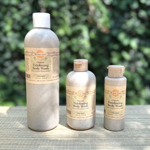 Puede incluir: Tres botellas marrones de gel de baño exfoliante orgánico con cáscaras de nuez trituradas. Las botellas están etiquetadas con "The Soap Opera" y están disponibles en tres tamaños: 500 ml, 250 ml y 200 ml.