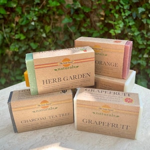 以下が含まれることがあります： 茶色の紙のラベルが付いた、天然石鹸が5本。ラベルには「The Soap Opera naturals」と、ハーブガーデン、チャコールティーツリー、グレープフルーツ、オレンジの香りの名前が書かれています。