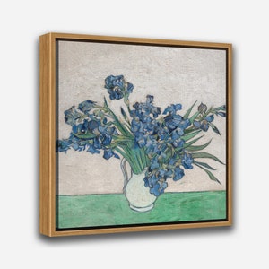 May include: A painting of a white vase filled with blue irises. The vase is on a green table with a white background.