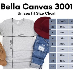 May include: A light gray Bella Canvas 3001 t-shirt with a size chart. The chart shows measurements for XS to 4X sizes, with lengths from 27 to 34 inches and widths from 16.5 to 30 inches. A pair of brown shoes and a burgundy hat are also visible.