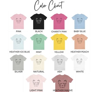 May include: A color chart displays various t-shirts in different colors, including pink, black, and blue. Each shirt features a cat face design with the text "All you knead is love". The chart lists the color names.