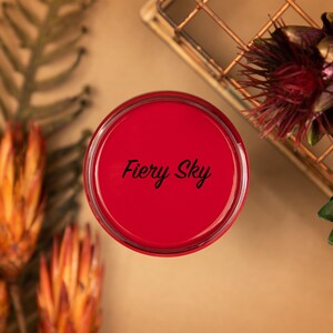 May include: A small red paint can with the words "Fiery Sky" printed in black on the lid.