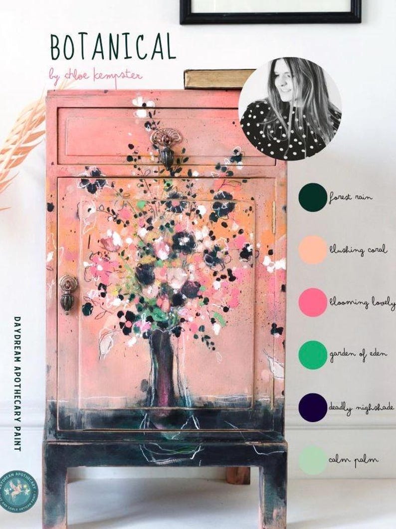 Puede incluir: Un armario de madera pintado de rosa con un dise&ntilde;o floral pintado en la parte delantera. El armario tiene una sola puerta y dos cajones. El armario est&aacute; pintado en una variedad de colores, incluyendo rosa, verde, azul y negro. El armario est&aacute; sentado sobre un fondo blanco. El texto "BOTANICAL by chloe kempster" est&aacute; escrito encima del armario. El texto "DAYDREAM APOTHECARY PAINT" est&aacute; escrito en el lateral del armario.
