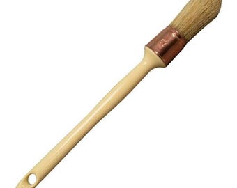May include: Angled paint brush with a cream-colored handle and natural bristles. The brush head is secured with a copper-colored ferrule. The handle has a hole for hanging. Ideal for painting furniture and craft projects.